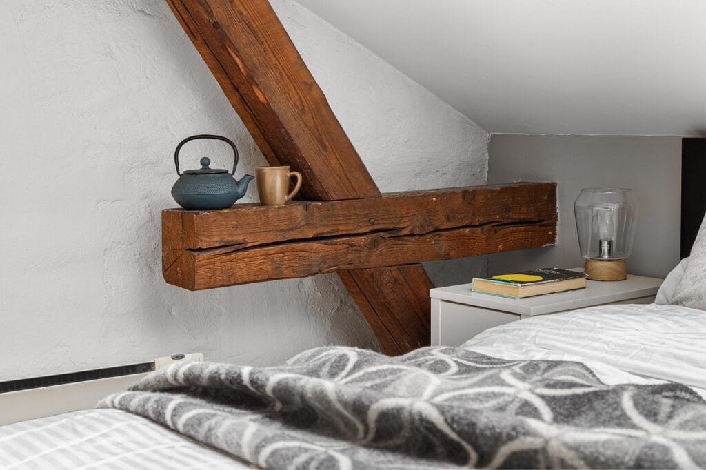 Chambre sous combles avec poutre apparente et décoration chaleureuse